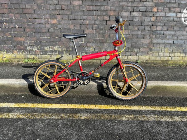 Mongoose 1981 Motomag Custom Bike Red and Gold 1 1981 Mongoose Motomag BMX Bike in red and gold, featuring Motomag III wheels and premium Japanese components.